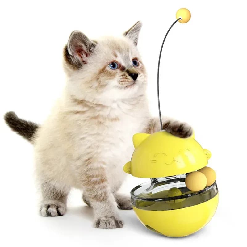 Kätzchen mit einem gelben Futterball für Katzen